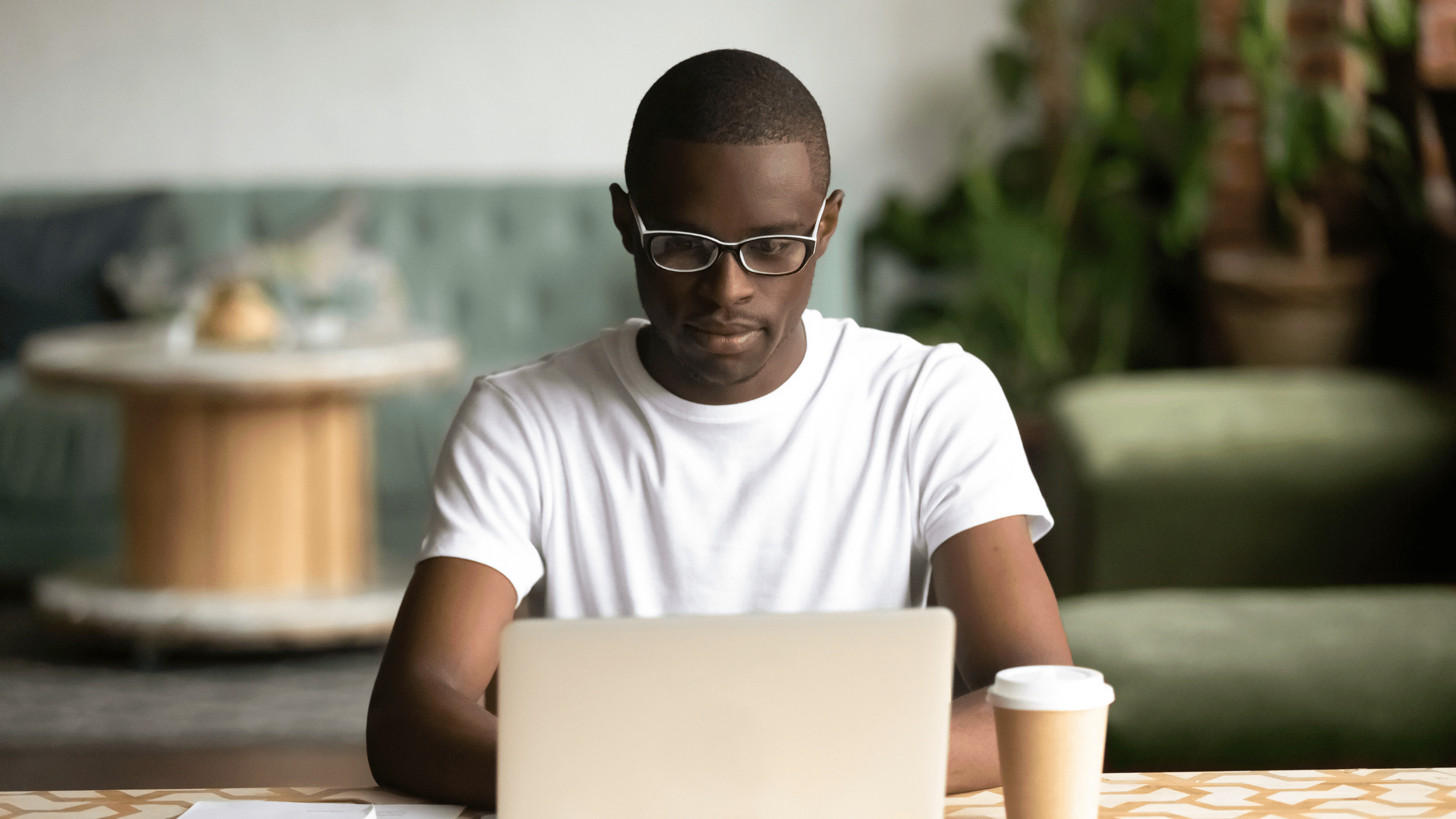 A premed student studying for the MCAT in a cafe in front of a laptop.